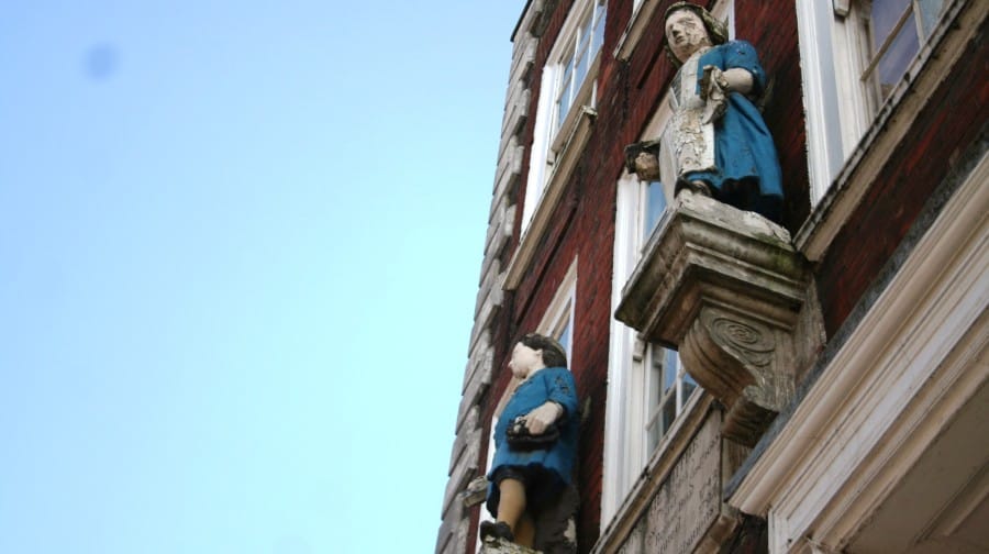 The stone statues of Charity School children in their bluecoats still guard the entrance to the building