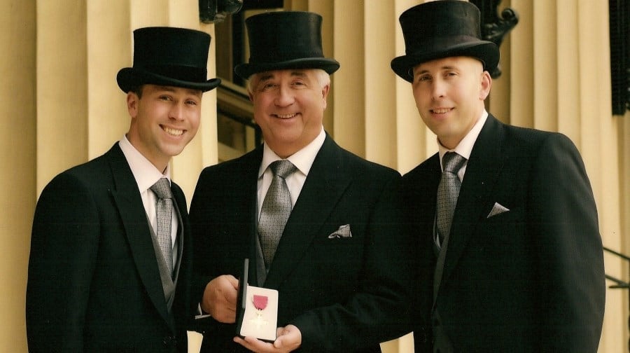 Barry proudly displays his OBE medal with sons Jon and Simon at Buckingham Palace