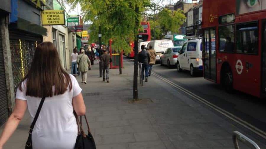 A woman in a medical boot walks past traffic at a standstill. Photo: Beverley Hunt