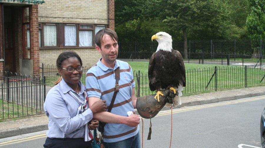 A surprised residents poses for a photo with the eagle and its handler.