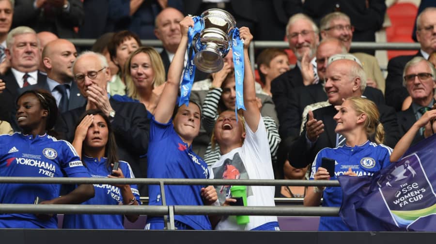 Gilly (in white t-shirt) lifting the Women's FA Cup trophy.