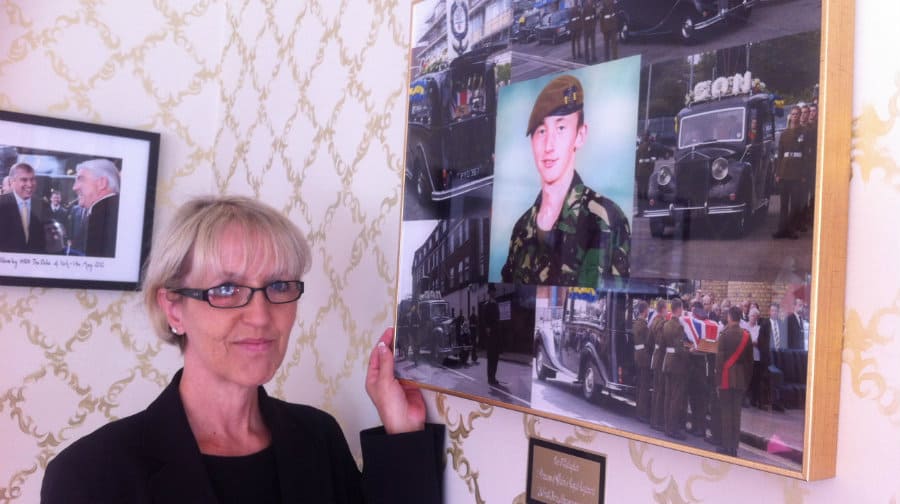 Lee's mum Shirley proudly showing off his photograph at her place of work in the Albins office in Walworth