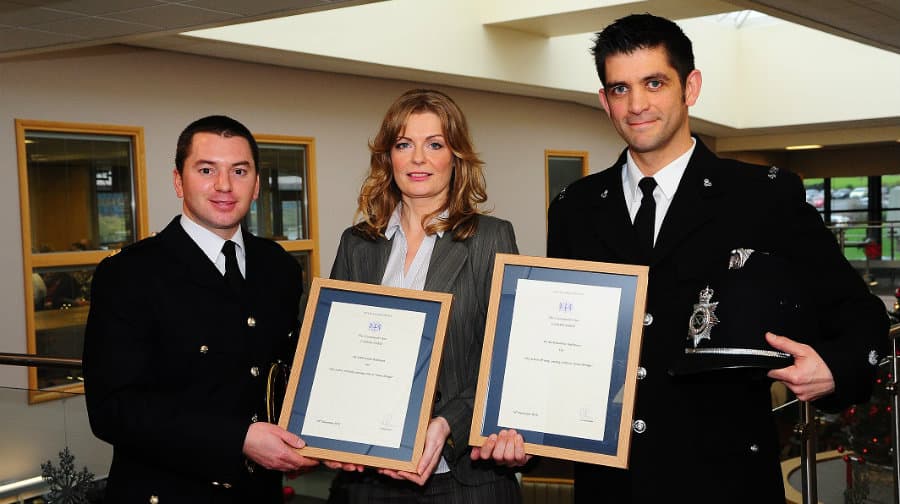 Dominic (right) and Louise Gallimore (center) receiving their commendation from a City of London Police representative