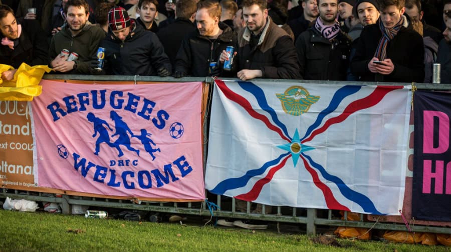 Dulwich fans with a pro-refugee banner and an Assyrian flag at a recent match. (Photo: Duncan Palmer)