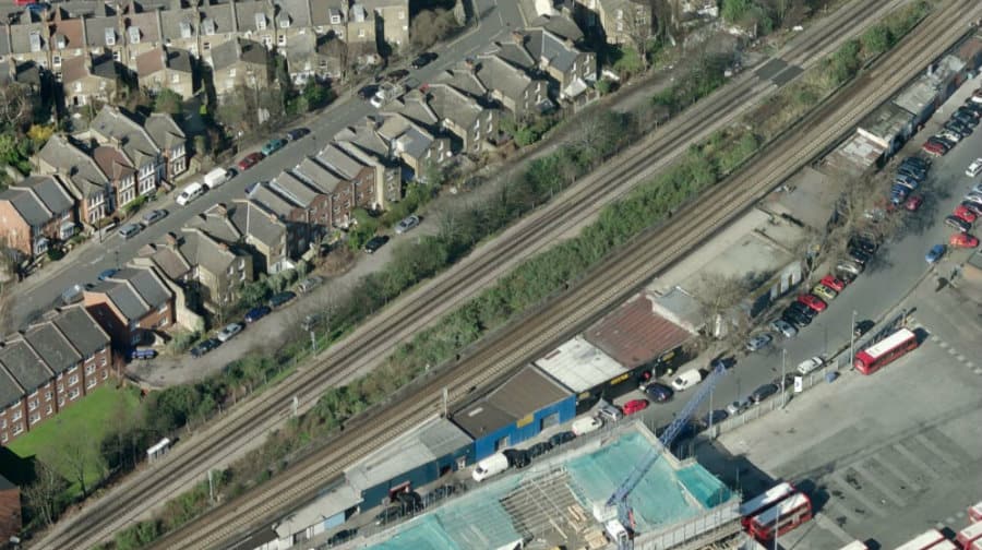 An aerial shot of the station today showing the platforms overgrown with brush