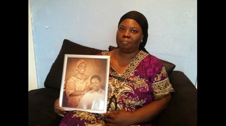 Andrew's mum, Tina Ababio, holds a photo of herself and her late son