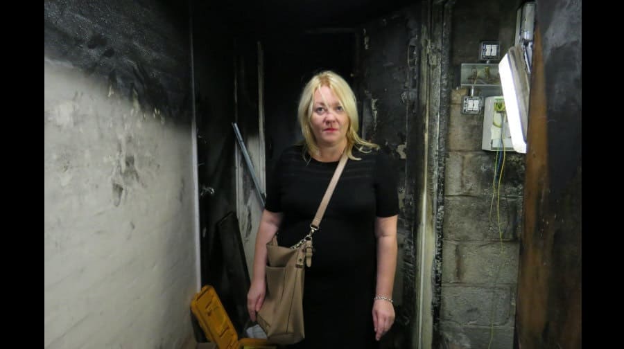 Maria Hayes inspects the burnt out fuse box cupboard that was raided by rough sleepers
