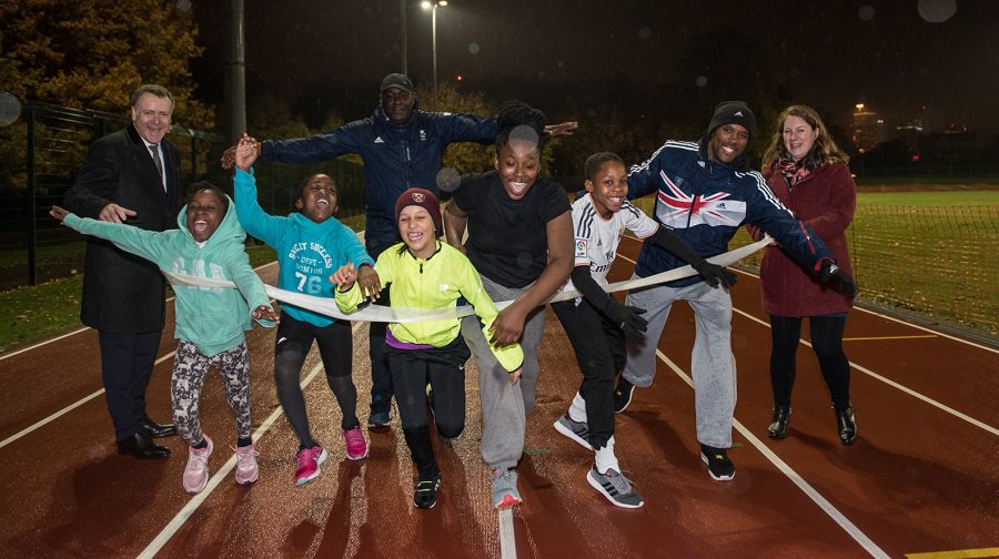 Southwark Park athletics track. From the back left, cllr Peter John,Conrad Williams, Lloyd Cowan, cllr Maisie Anderson, joined by kids from London City Athletics Club.
