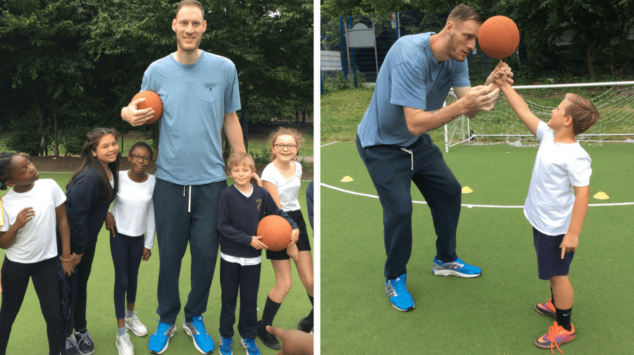 The UK's tallest man, Paul Sturgess, with pupils at Peter Hills Primary School