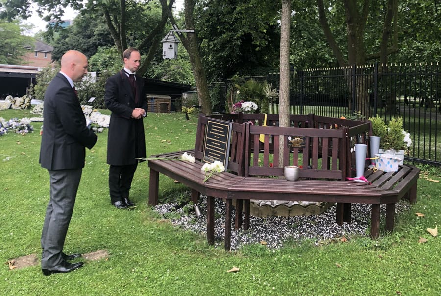 Simon and Jon Dyer lay the eight rose at the tree in Albin's memorial garden