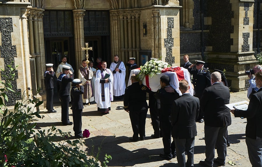 Representatives of the Royal Navy salute war veteran Bernie Coot's coffin outside Southwark Cathedral