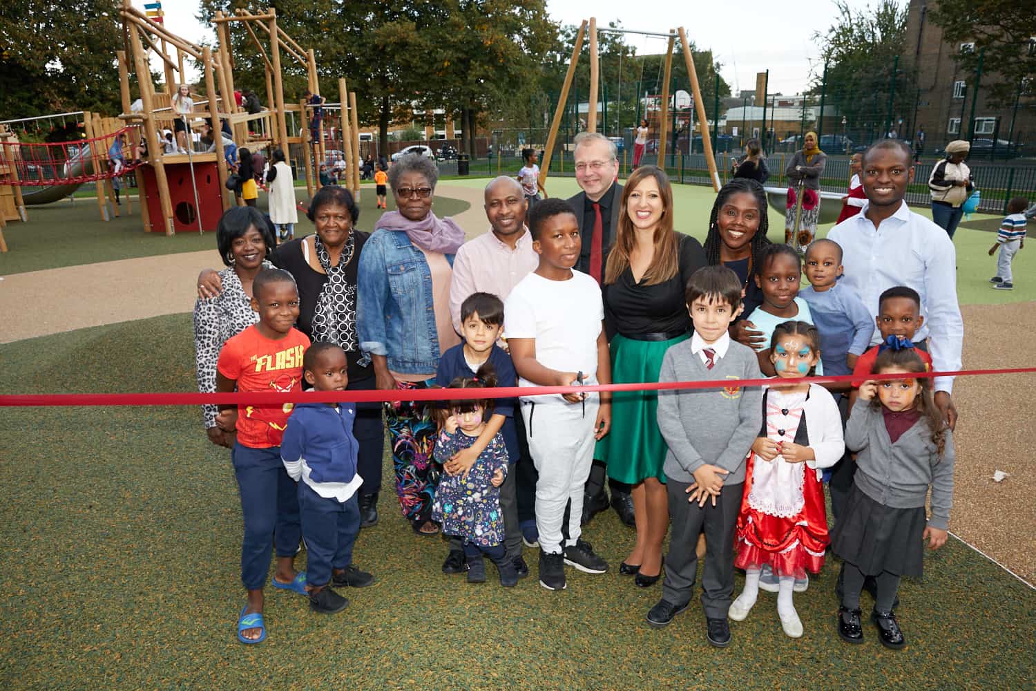 Local families smile alongside Cllr Lury as the new play area is unveiled