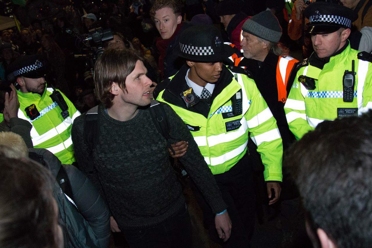 A protester being escorted by police on Waterloo Bridge last night