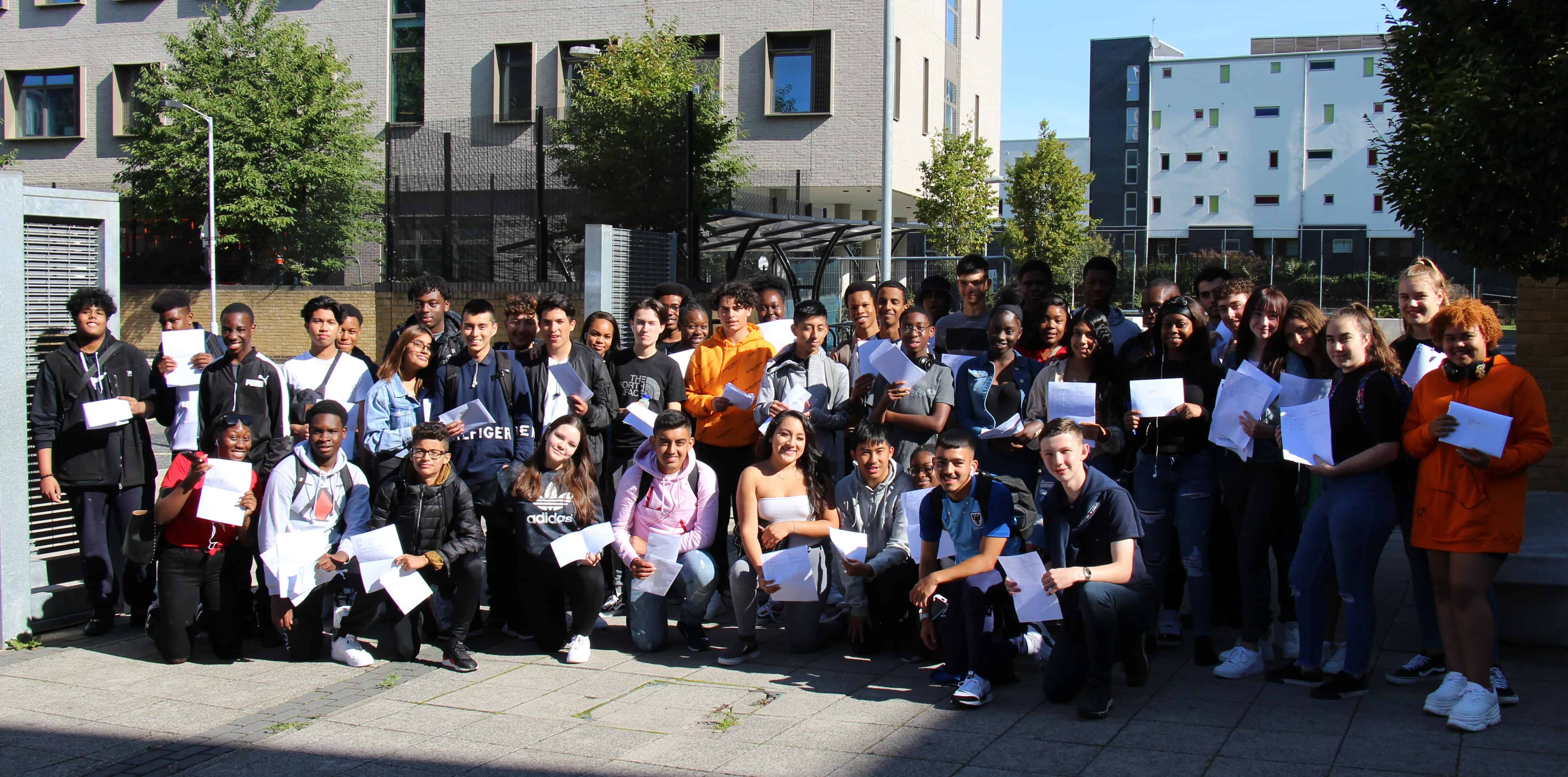 Students pose with their results today at the entrance to St Michael's College in Bermondsey
