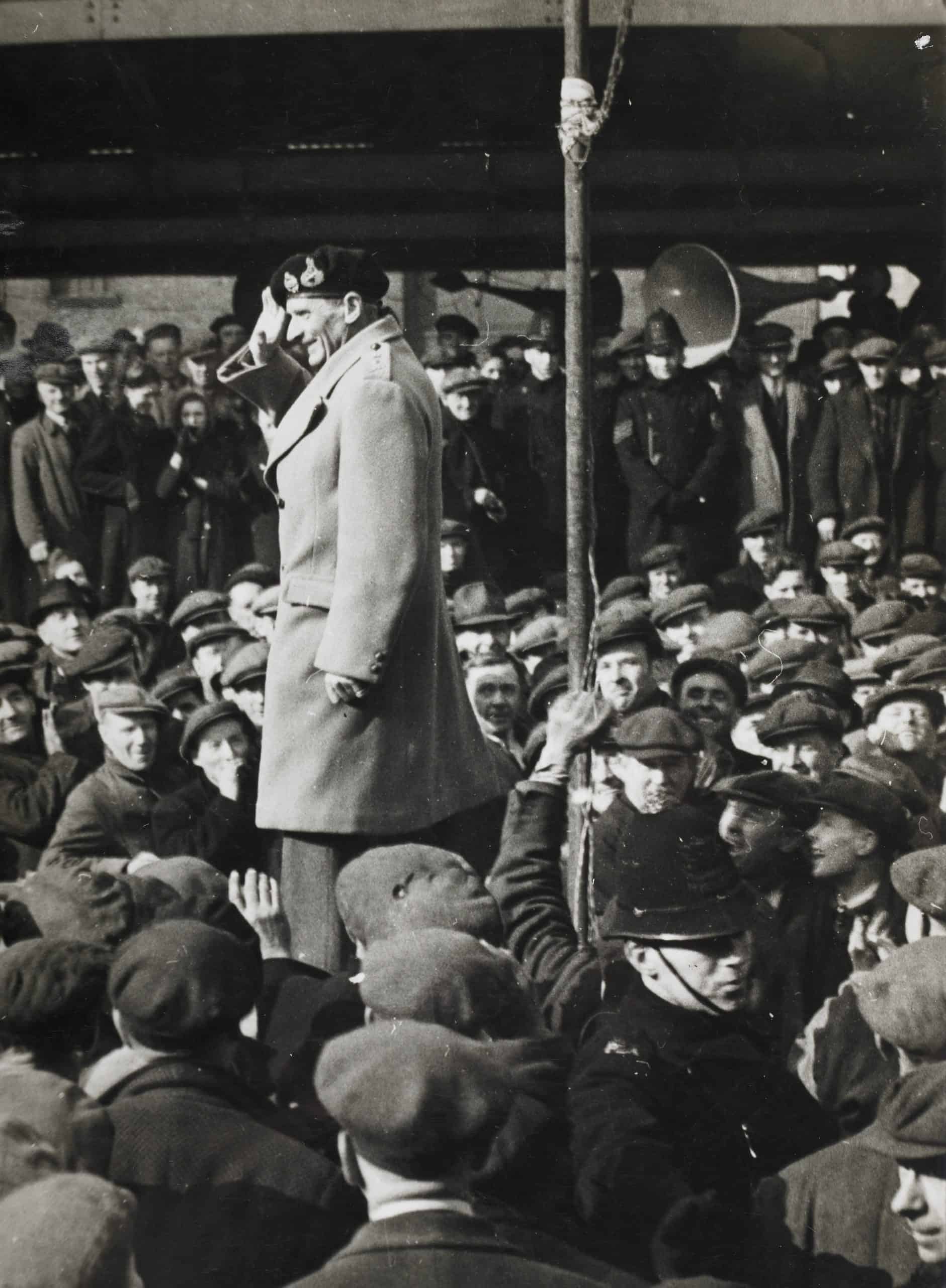General Montgomery speaking to 16,000 port workers before the invasion of France in June 1944. His speach was relayed by microphone to every dock and major wharf in London. He was telling them of their vital role in the build up to D-Day.