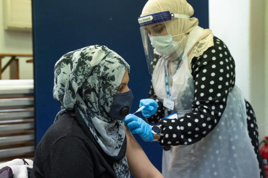 Amira Alam is vaccinated by Jabeen Razvi at the South London Islamic Centre