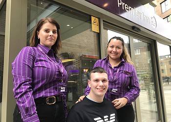 Cameron outside the Premier Inn with his new colleagues Roxana (left) and Gladys (right)