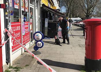 A police dog and its handler at the scene of a stabbing on Ilderton Road, Bermondsey.