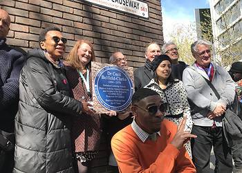 Event organisers and friends hold a plaque mock-up with Jak Beula, Nubian Jak founder, at the front