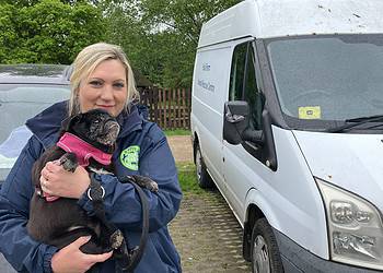 Lucy Bennett, finance manager for Foal Farm, shown with Bug the pug in front of the farm's current animal ambulance. Photo by  Joe Coughlan.
