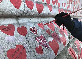 A volunteer repainting one of the hearts
