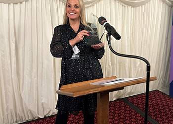 Jo Watts proudly holds her award.