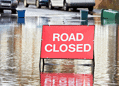 A stock image of a road closure sign in a flood road